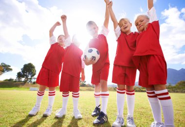 Çocuklar, futbol takımı ve galibiyet ya da zafer kutlamaları, dışarıda mutluluk ve başarı. Başarı, işbirliği ve ortaklık için insanlar, çocuklar ve yumruk pompası ya da sahada ya da sporda takım çalışması.