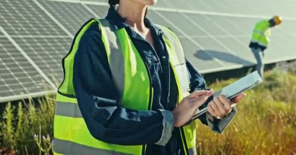 クリーンエネルギー 屋外の電力網の維持および点検のためのタブレットが付いている太陽電池パネルの農場の女性 安全点検のためのヘルメットが付いている持続可能性 太陽光発電システムおよび技術者 — ストック動画
