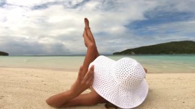 Kadın, plajda uzanmış, arka manzaralı kum, tatil ya da tatil deneyimi için, rahatla ve huzur. Yazın yolculuk, dinlenme ve şapkayla kaçmak için okyanusta veya bacaklarda mayo ve yelek..