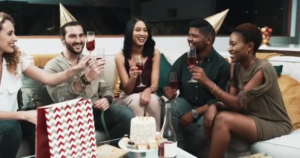 生日宴会上 朋友们举杯庆祝 在沙发上庆祝成功和欢呼 一群人 男人和女人 他们带着酒精 饮料和蛋糕过节 晚上在社交 — 图库视频影像