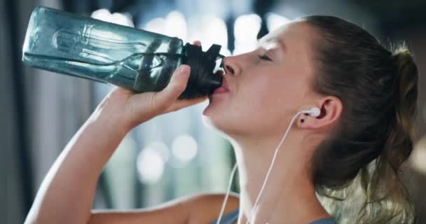 在训练 锻炼或日常活动中 健身房 健身中心和妇女用耳机喝水 在演播室进行健康锻炼的女运动员的饮水量 瓶装水量或脸部 — 图库视频影像