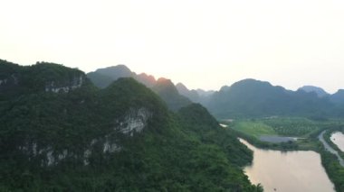 Doğa, insansız hava aracından gelen orman ve nehirli dağlar, Vietnam 'da seyahat ve orman ortamı. Ağaçlar, tepe ve yeşil çalı. Doğal su manzaralı, açık hava manzaralı ve dünyanın uzak bir yerinde.