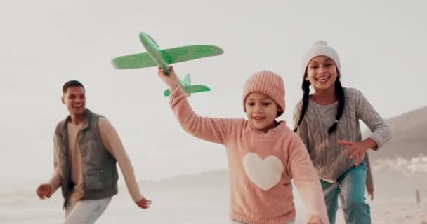飛行機 ランニング 家族とビーチでゲーム ボンディング 自然の中で一緒に休暇で遊びます 飛行機で海で親を持つ愛 そして子供たち 飛行機に乗って楽しむ — ストック動画