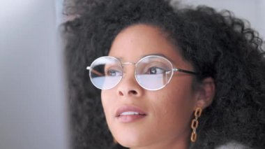 Moda gözlüklü bir iş kadını ofiste çalışırken bilgisayar ekranından bilgi okuyor. Çevrimiçi raporları ve planları dikkatlice incelerken kendine güvenen bir girişimcinin yakınlaşması.