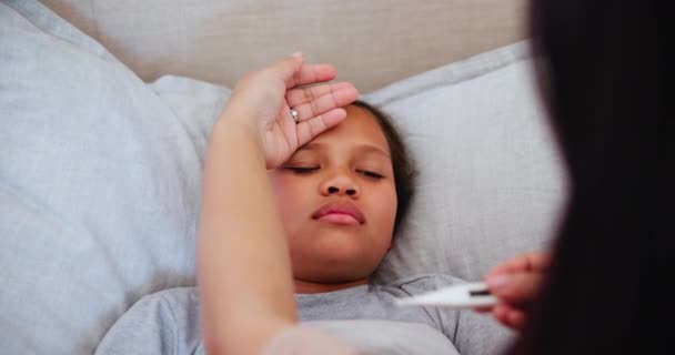 집에서 침대에서 독감을 확인하기 아이와 온도계 바이러스가있는 아이의 어머니 — 비디오