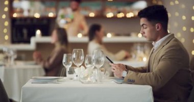 Restoran, randevu ve adam telefonda bekliyor, yalnız oturuyor ve online randevulardan bıkmış durumda. Okuma, sosyal medya ya da yalnız insan internet uygulaması ile akşam yemeğinde akıllı telefona kayar.