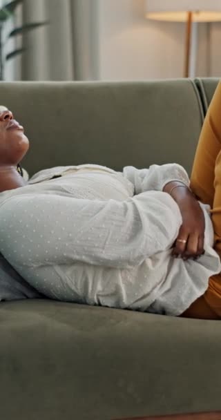 ソファー 胃の問題 月経クランプ 期間または子宮内膜症の痛み 黒人女性 下痢または腹部ガス ヘルニアまたは腫瘍の痛みを伴うソファーにいる人 — ストック動画
