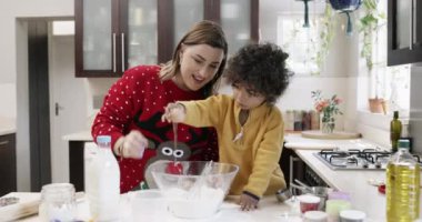 Çocuk, anne ve babanın Noel 'de mutfakta yemek pişirmesine yardım etmek, geliştirme ya da öğrenme ile ilgili. Mutlu, anne ve çocuk birlikte yemek pişirmek ve hazırlamak, karışım veya tatil için evde yemek.