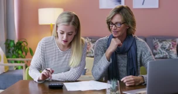ハッピーママ 電卓は 自宅での計画のための論文で財務に書いています 数学で計算する母と若い女性 家庭での文書のチューターや会計 — ストック動画