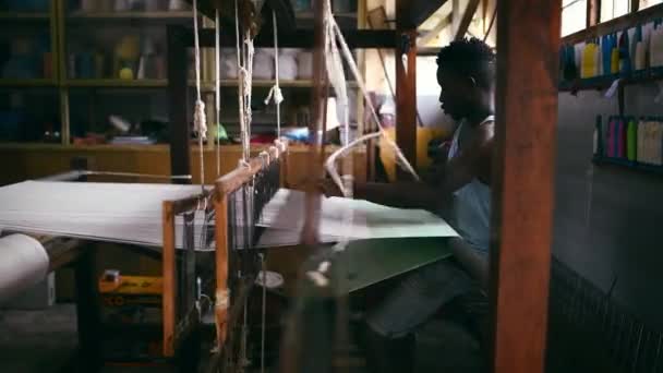 衣料品工場 職人技で人間 フロアトリードル織物 デザイン生産 黒い男性の人 倉庫および編む糸か綿の企業 ウールおよび生地か織物 — ストック動画