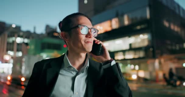ビジネスマン 屋外旅行のための市内の電話 ハッピーアジア人男性または従業員の笑顔と夜遅くにモバイルスマートフォンで話して都市都市で議論 — ストック動画