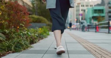 Kadın, Asyalı ve kaldırımda yürüyor, seyahat ediyor ya da işe giderken kulaklıklı profesyonellerle birlikte çalışıyor. Yolculukta müzik dinlemek, podcast ve banliyö sokaklarında Tokyo 'da müzik listesiyle gezmek.