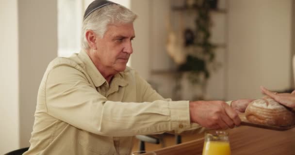 ユダヤ人の家族のランチ 愛と食べ物 シニアマン 子供と一緒に家でハヌカのために 祝宴やお祝い イベント 高齢男性のお父さんは 食事の伝統のためにパンを壊します — ストック動画