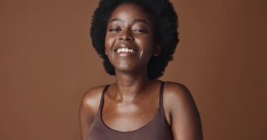 Yüzü, güzelliği ve estetiği stüdyodaki afro siyahi kadın, esmer arka planda, refah için izole edilmiş. Portre, gülümseme ve cilt bakımı, temel ya da dermatoloji için mutlu olmak..