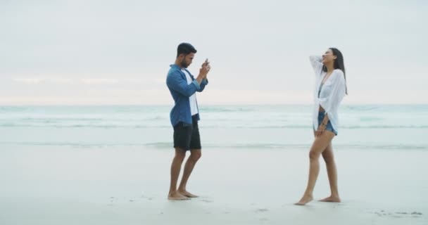 オーシャンビーチ 電話写真 ハッピーカップル 男女がトロピカルアイランド ハネムーン メキシコ旅行にポーズします またはソーシャルメディアの写真をアプリに投稿するスマートフォン — ストック動画