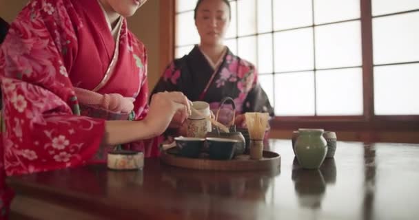 日本の女性は 一緒に 友人のための伝統的なお茶 敬意と優しさは テーブルでチャットでリラックスします 女の子 人々は カップ 家が付いている飲み物 マチャまたは先住民の服のために準備します — ストック動画