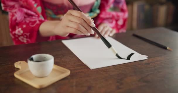 ペイントブラシ インク 創造性 伝統的なテキストでアジアの執筆またはスクリプト 日本のフォント 黒塗装の作家 アートとツールを備えたデスクにいる人 — ストック動画