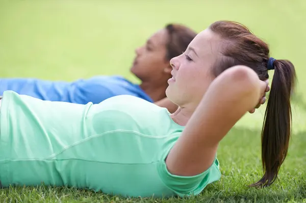 坐起来 在绿草上锻炼 以便在大自然中一起健身或户外运动 处于核心 腹肌或力量训练中的年轻活跃女性 躺在室外 — 图库照片