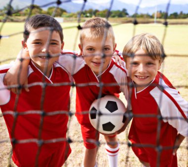 Çocuklar, futbol takımı ve gülümseyen bir portre, gol ağı ve takım çalışması, destek ya da dayanışma olan çocuklar. Enerji, spor ve arkadaşlık, birlikte ve kazanmak için mutlu, oyun ve fiziksel aktiviteye hazır.