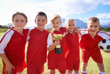 Portre, futbol takımı ve kupalı çocuklar, zafer kazanmış kızlar ve erkekler, destek ya da gurur. Başarı, spor ve arkadaşlık, birlikte ve kazanmak için mutlu, oyun ya da fiziksel aktivite için hazır.