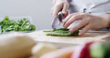 İnsan, el ve yeşil fasulye veya sebzeler yemek veya beslenme için sağlıklı yemek hazırlamak için mutfakta. Akşam yemeği, bıçak ve kesim tahtası, brunch veya öğle yemeği için yakın çekim vejetaryen yemeği.