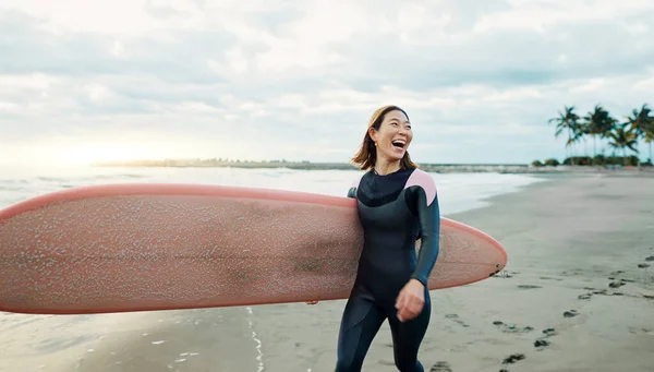 Woman, surfing board and laughing at beach, sea and ocean for summer holiday, travel adventure or hobby. Happy Japanese surfer excited for water sports, freedom or fun for tropical vacation on island.