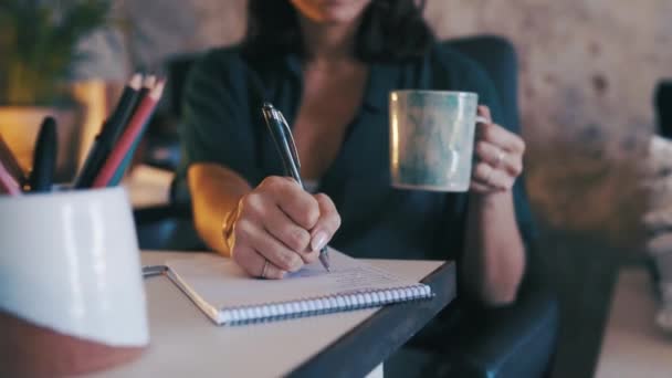 小規模なビジネスプランニング ブレインストーミング スタートアップのためのノートブックまたはコーヒーで女性 手と執筆 インスピレーション プロジェクトのクリエイティブオーナーとしての個人 オフィス または会社の決定 — ストック動画