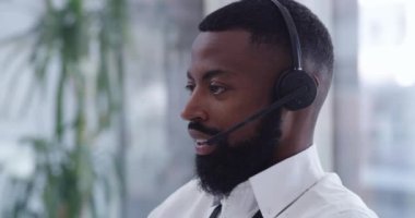 Siyah bir adam, kulaklık takıyor ve çağrı merkezinde konuşuyor, müşterilere satış temsilcisiyle çalışıyor ve tele-pazarlama yapıyor. Afrikalı, dost canlısı ve danışmanlardan telefon, danışma ve müşteri hizmetleri.