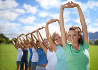 Spor sahasında egzersiz yapmak için kollarını açan kadınlar ve fitness sınıfında takım. Sağlık, portre ve birlikte eğitim, parkta spor yapan genç sporcular ve ısınan fiziksel aktiviteler..