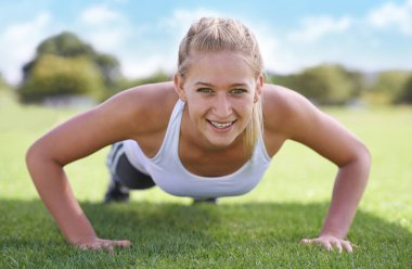 Kadınlar, portre ve spor sahasında egzersiz yapmak, antrenman yapmak ve egzersiz yapmak için çimlerin üzerinde şınav çekin. Sporcu, insan ve kendine güven, sağlıklı vücut ve sağlık için fiziksel aktivite..