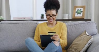 Kredi kartı, tablet ve koltukta başarılı bir kadın, alışveriş ve maaş zammı dairede. Kişi, evet jest ve bankacılık veya ev kredisi ve finansal prim veya çevrimiçi satıştan heyecan.