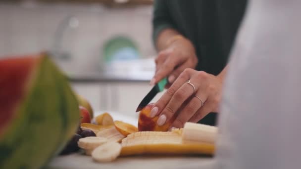 クローズアップ キッチン 女性は スムージー 健康的な飲み物 ダイエットプランを作るために果物を切ります 食材を使用した人 ナイフ エネルギー 体重減少による健康 — ストック動画