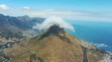 Hava aracı, dağ ve aslanlar bulutlu ve açık mavi gökyüzü manzaralı Cape Town 'a yöneldiler. Güney Afrika 'daki tepe, uçurum ya da kayalık yamaç manzarası, dönüm noktası ya da turistik bölge.