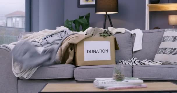 用于社区服务或社会责任 非营利或慈善事业的盒子 捐赠和服装 客厅里的时装 套件和沙发 用于支持项目或推广计划 组织或帮助 — 图库视频影像