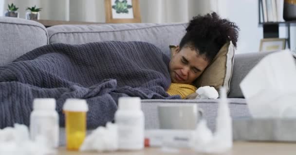 女性は 回復または薬によるアパートのインフルエンザアレルギーとしてソファーで鼻やティッシュを吹き飛ばします ブラジル人 冷たいか ソファーで休憩中にくしゃみ 家のリビングルームでボトルや熱を丸める — ストック動画