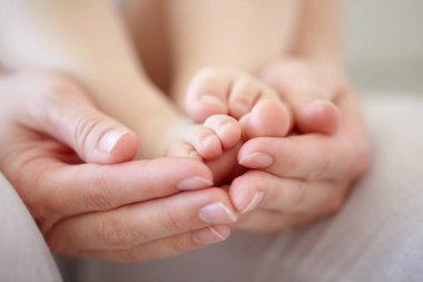 Sevgi, anne ve bebek sahibi eller ya da gelişim için ayaklar, bakım ve bağlanma dairede. Aile, kadın ya da yeni doğmuş ayak parmakları evde rahatlama, destek olma ya da ilişki ya da annelik için bakım.