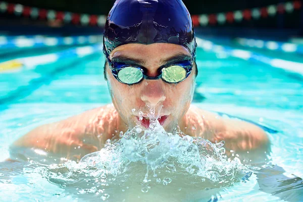Athlete man, swimming pool and sport with splash, speed or exercise for wellness, health or fitness. Swimmer, closeup and person in water for training, contest or workout with goggles in summer games.
