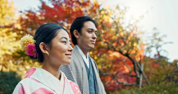 Asian couple, walking in garden and sunshine, peace and thinking about life, reflection and date in nature. Travel, people together in Japanese park for fresh air and calm with love, care and trust.