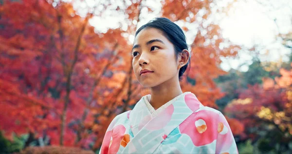 Woman in park, Asian and peace, thinking about life with reflection and tranquility in traditional clothes. Travel, Japanese garden and nature for fresh air, inspiration or insight with floral kimono.