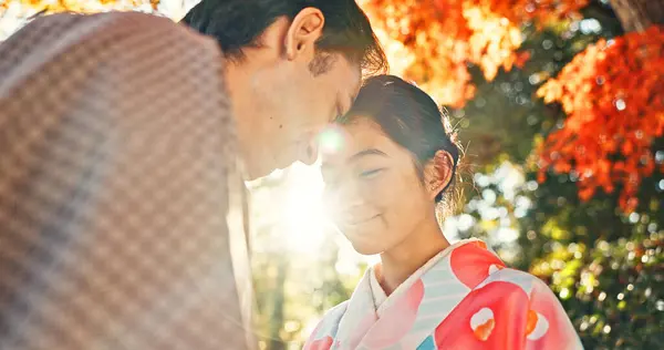 Couple, forehead touch and sunshine with love in park, Japanese people together on date with love and affection. Lens flare, summer and man with woman outdoor, commitment and loyalty with peace.