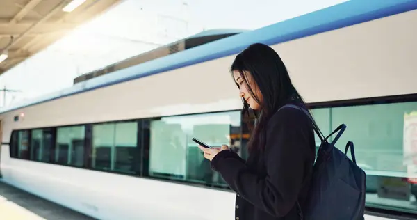Woman, phone and outdoor, city or train for travel information, schedule or social media in Japan. Asian student thinking with backpack and mobile search for location, metro or subway transportation.
