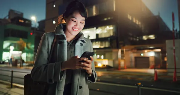 Asian woman, phone call and laughing at night in city for funny joke, conversation or outdoor travel. Happy female person smile and talking on mobile smartphone in late evening for discussion in town.