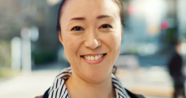 Mature, Asian woman in city and face with travel or commute to work and professional in Tokyo. Corporate lawyer in urban street, journey to office and happiness in portrait with business mindset.