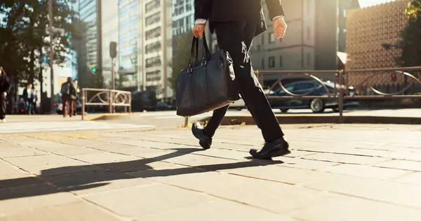 Legs, bag and business person walking, worker travel or commute to work in city with buildings. Corporate professional, sidewalk on urban street and journey to office with commuter in the morning.