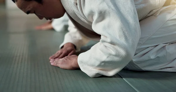 Asian man, student or bow in dojo for respect, greeting or honor to master at indoor gym. Closeup of male person or karate trainer bowing for etiquette, attitude or commitment in martial arts class.