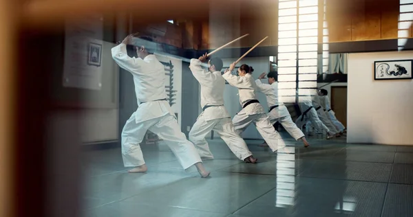 Aikido, dojo class and people training for self defense, combat and Japanese group practice sword technique. Black belt students, transparent window and learning martial arts for safety protection.