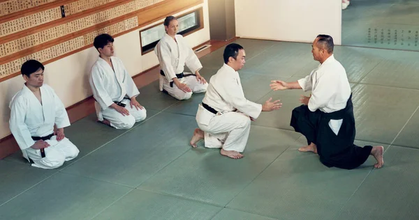 Aikido, class and fight with a master in martial arts with student in self defence, discipline and training. Technique, demonstration or Japanese sensei with black belt skill in fighting or education.