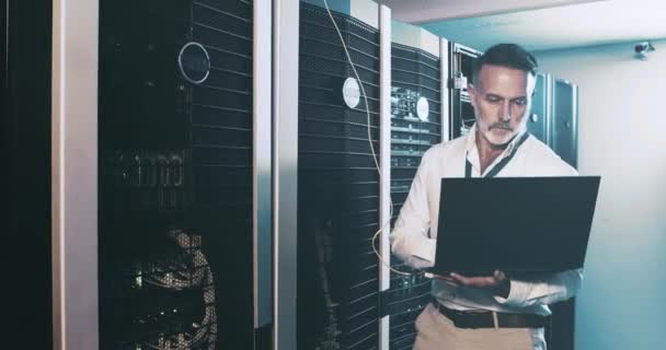 Homem Maduro Data Center Com Laptop Manutenção Internet Engenheiro Armazenamento — Vídeo de Stock