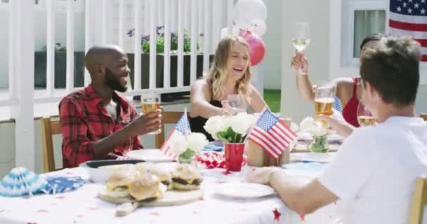 パーティーでの友人 アルコール アメリカンフラッグ バーベキューアウトドアでの独立記念日 多様性 7月4日にビールとワインで楽しむ アメリカで乾杯する人々 — ストック動画