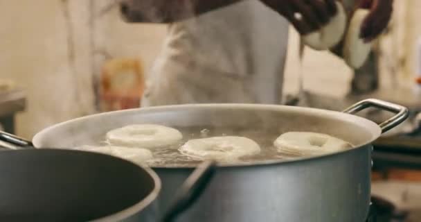 人的手和烹调百吉饼在锅里与厨师 食物和面包在餐馆 咖啡店 油品店和一家小饭馆专业烘焙师的伙食供应 — 图库视频影像